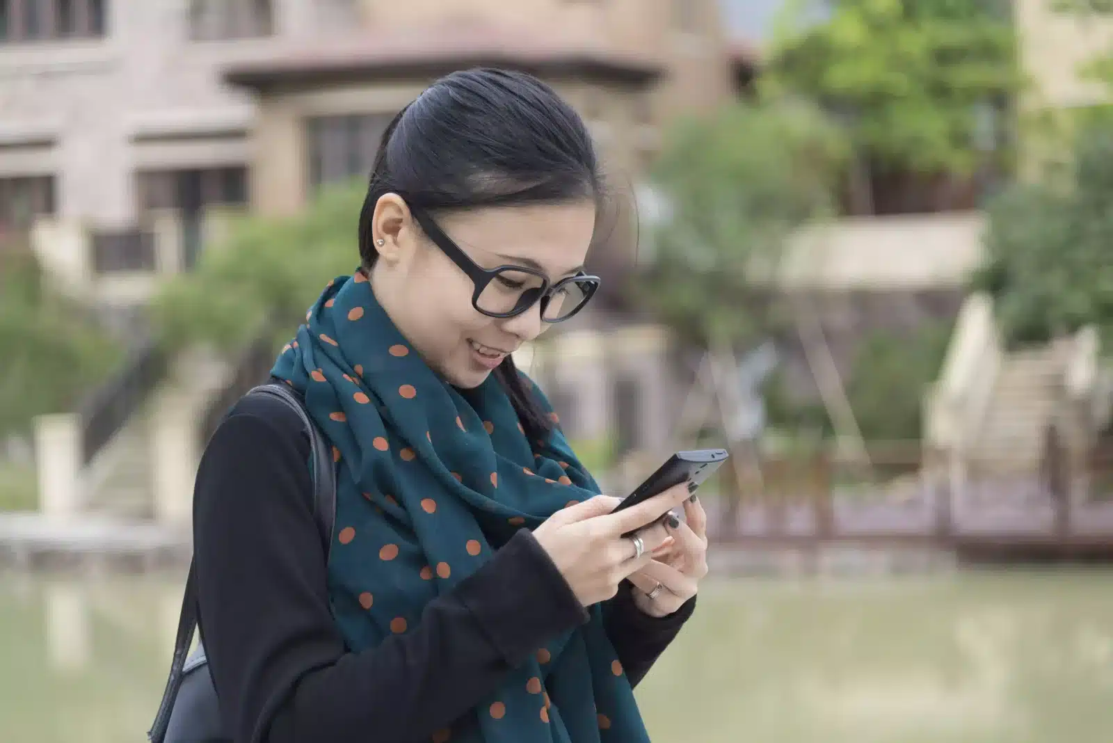 women holding her phone & smiling