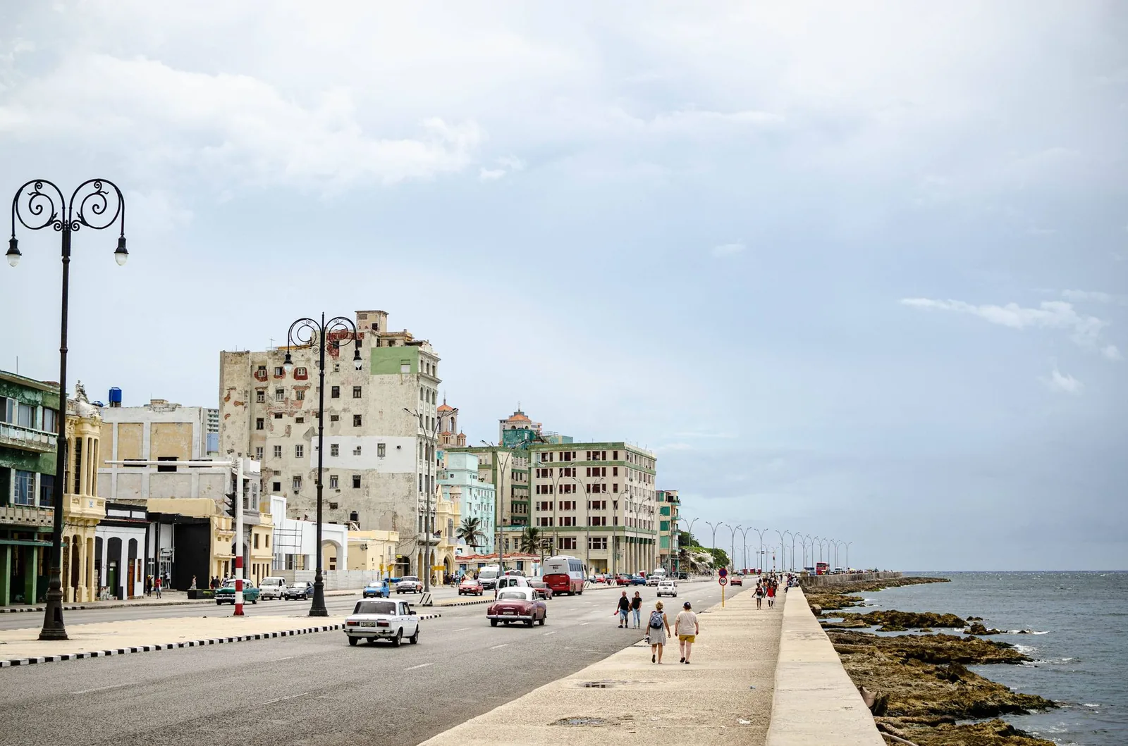 Havana's Malecon seafront promenade along the ocean, vintage cars and colorful facades, Cuba