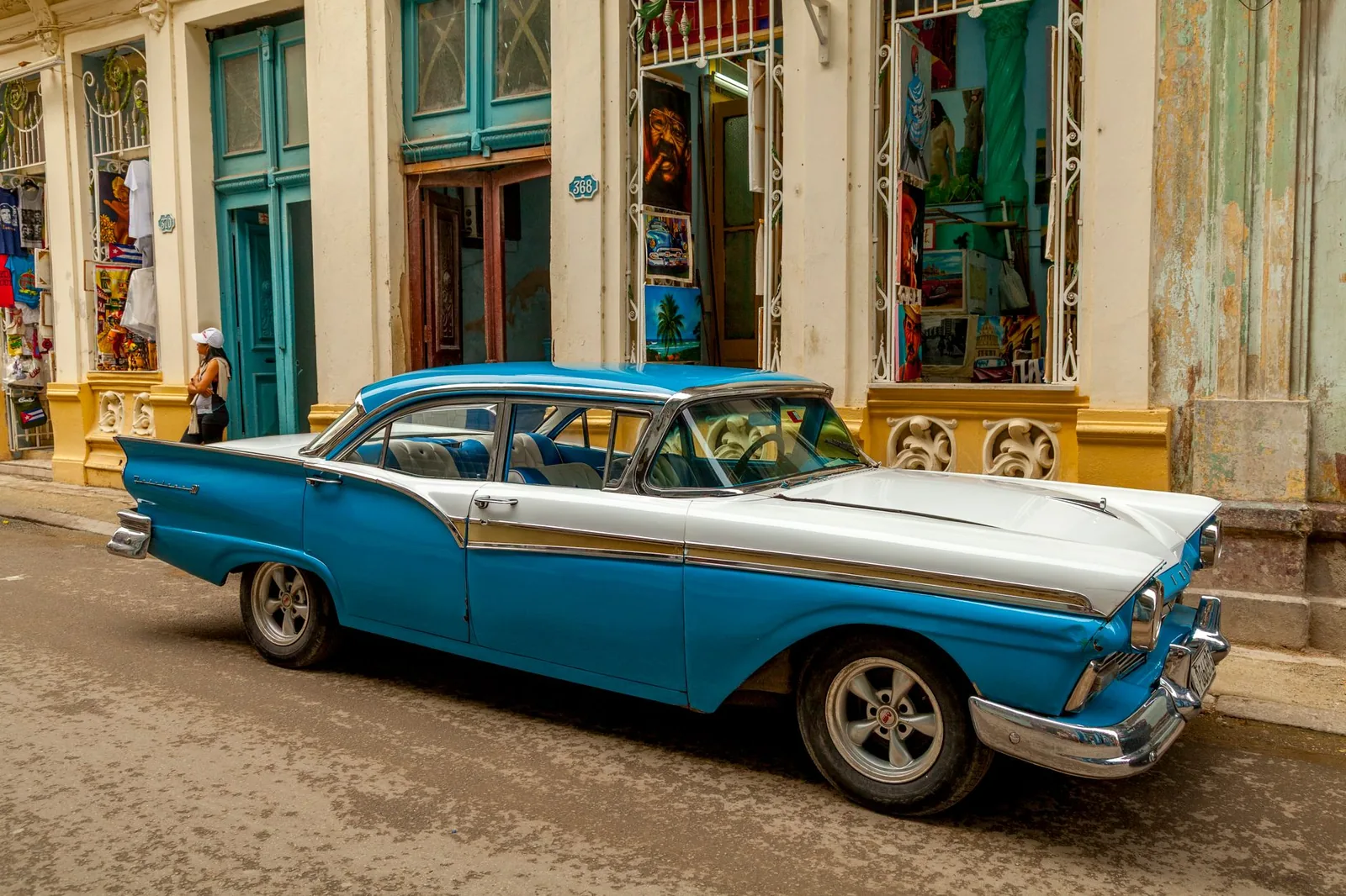 Vintage blue American car parked on a colorful street in Havana, Cuba