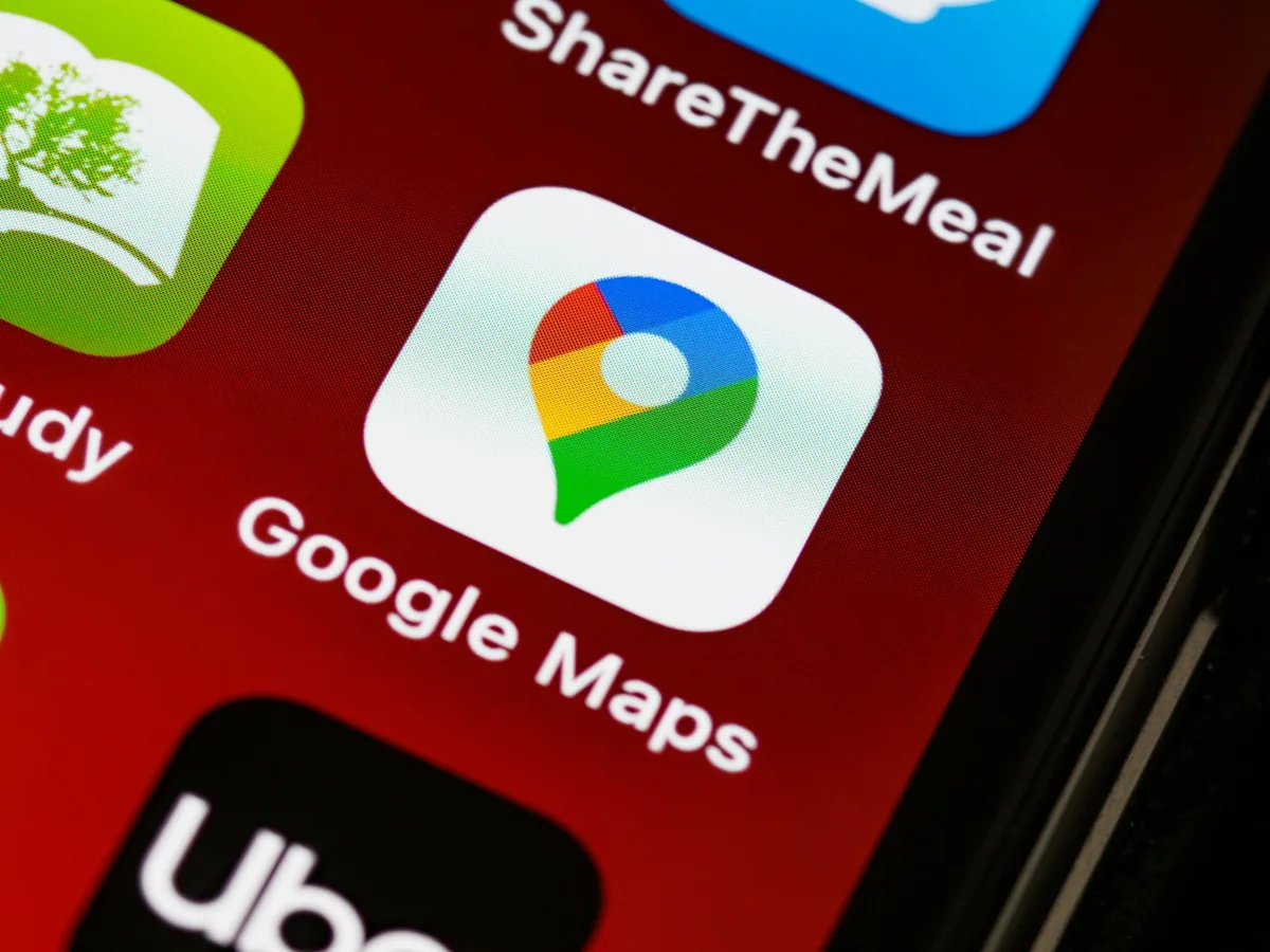 Traveller's smartphone showing a ride-hailing app map in central Tirana with the city street behind