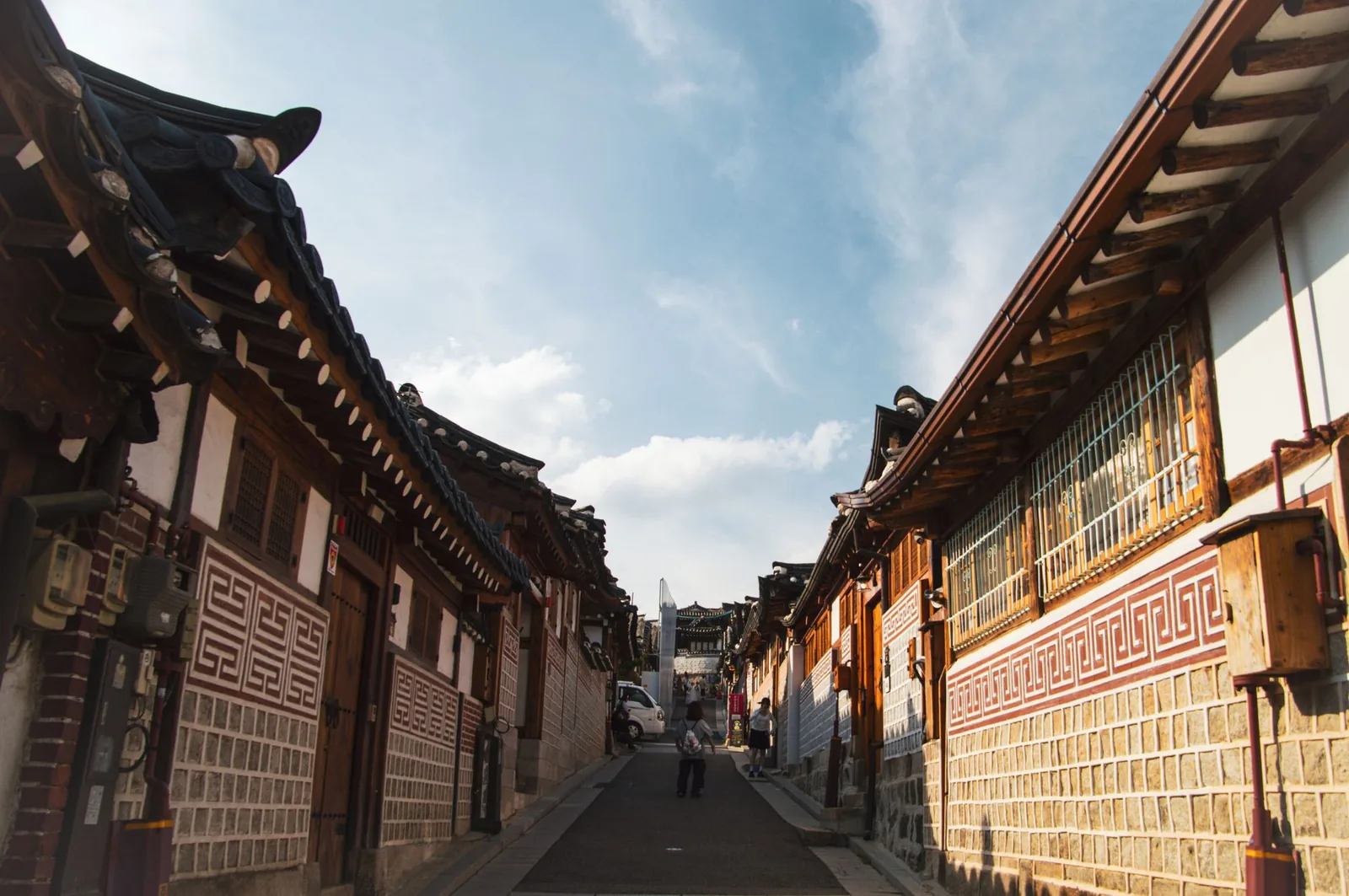 Traditional alley of Bukchon Hanok Village in Seoul, old houses with curved tiled roofs under a clear sky