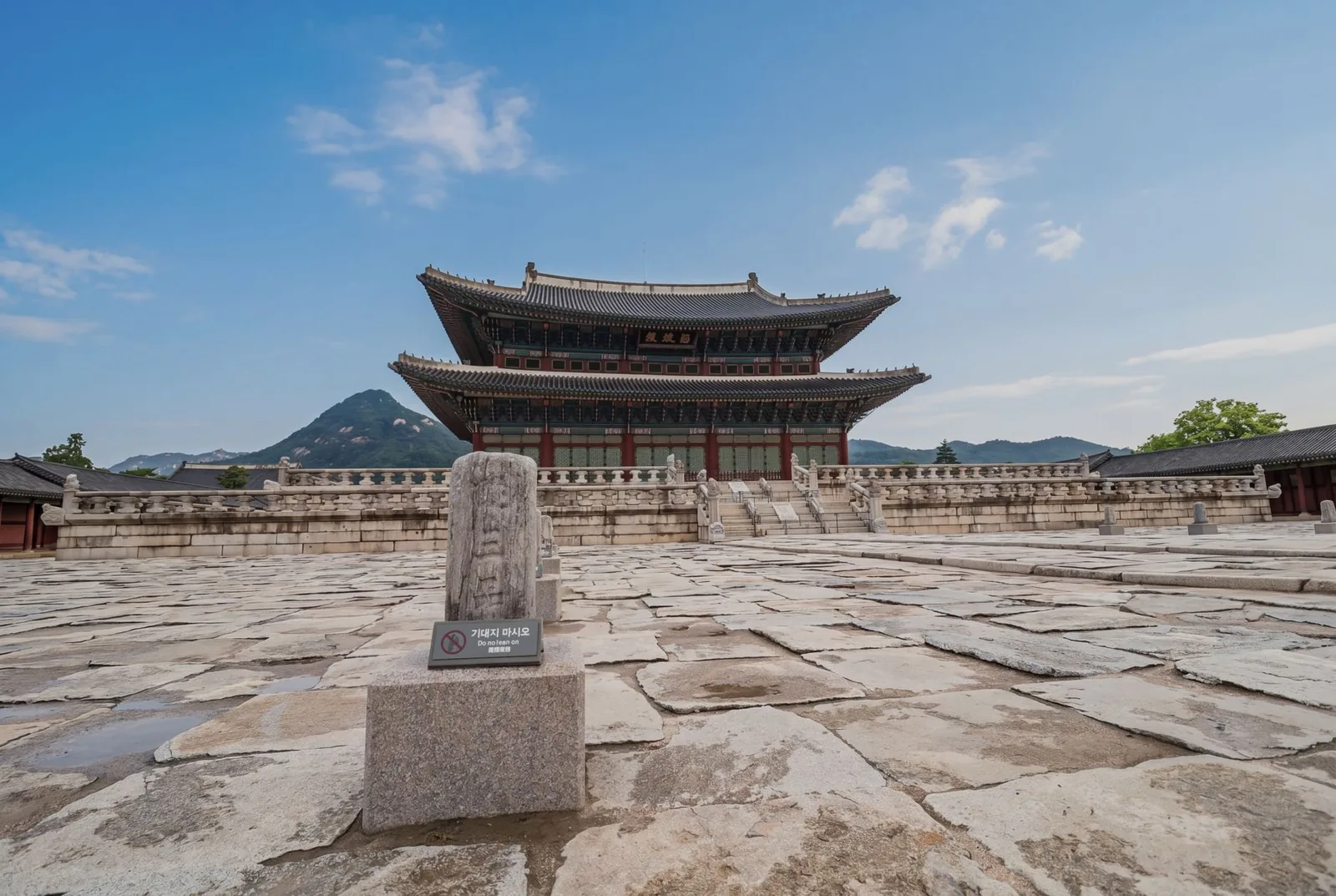 Gyeongbokgung Palace in Seoul and its throne hall, set against a mountain under a blue sky
