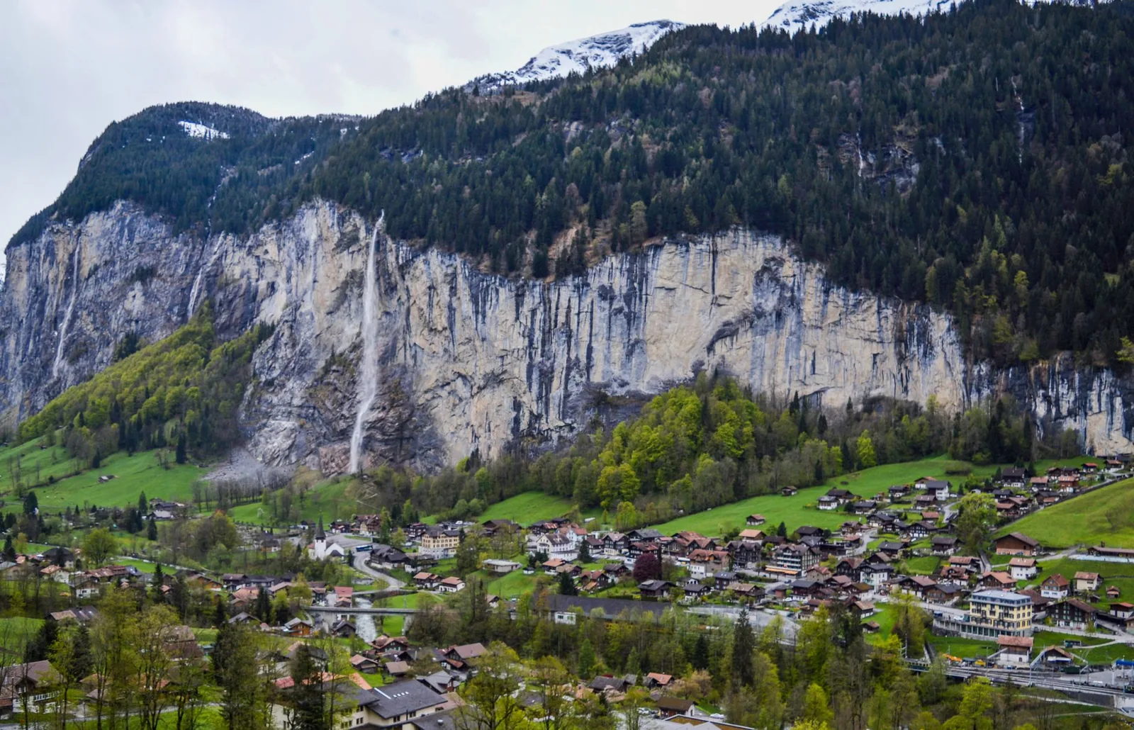 The Lauterbrunnen valley with the Staubbach waterfall, the village and towering alpine cliffs, Switzerland