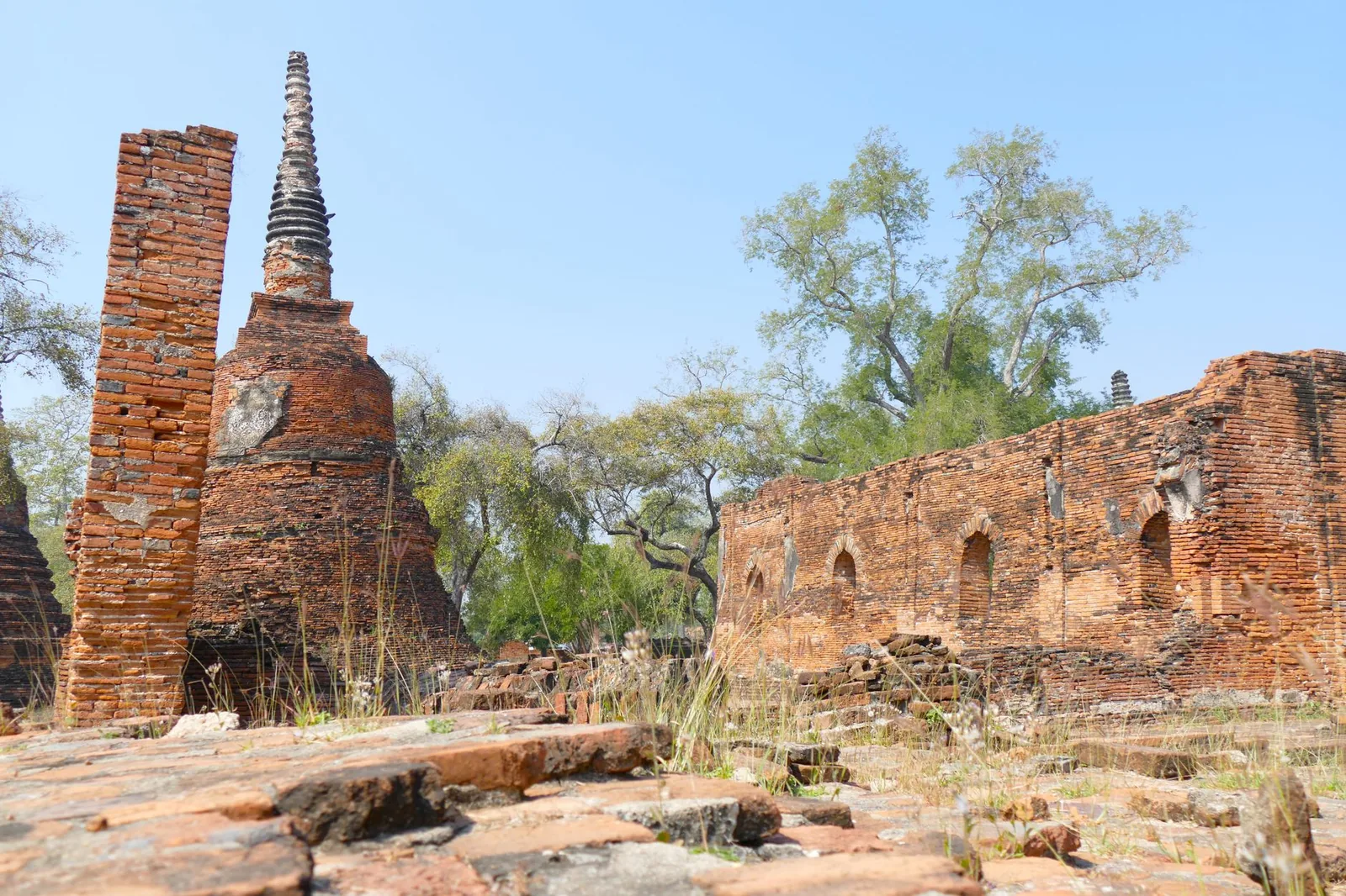 The brick ruins and ancient pagodas of the Ayutthaya historical park in Thailand under a clear blue sky