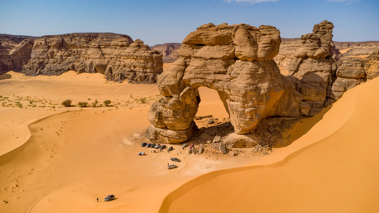 Natural sandstone arch in the golden dunes of the Algerian Sahara