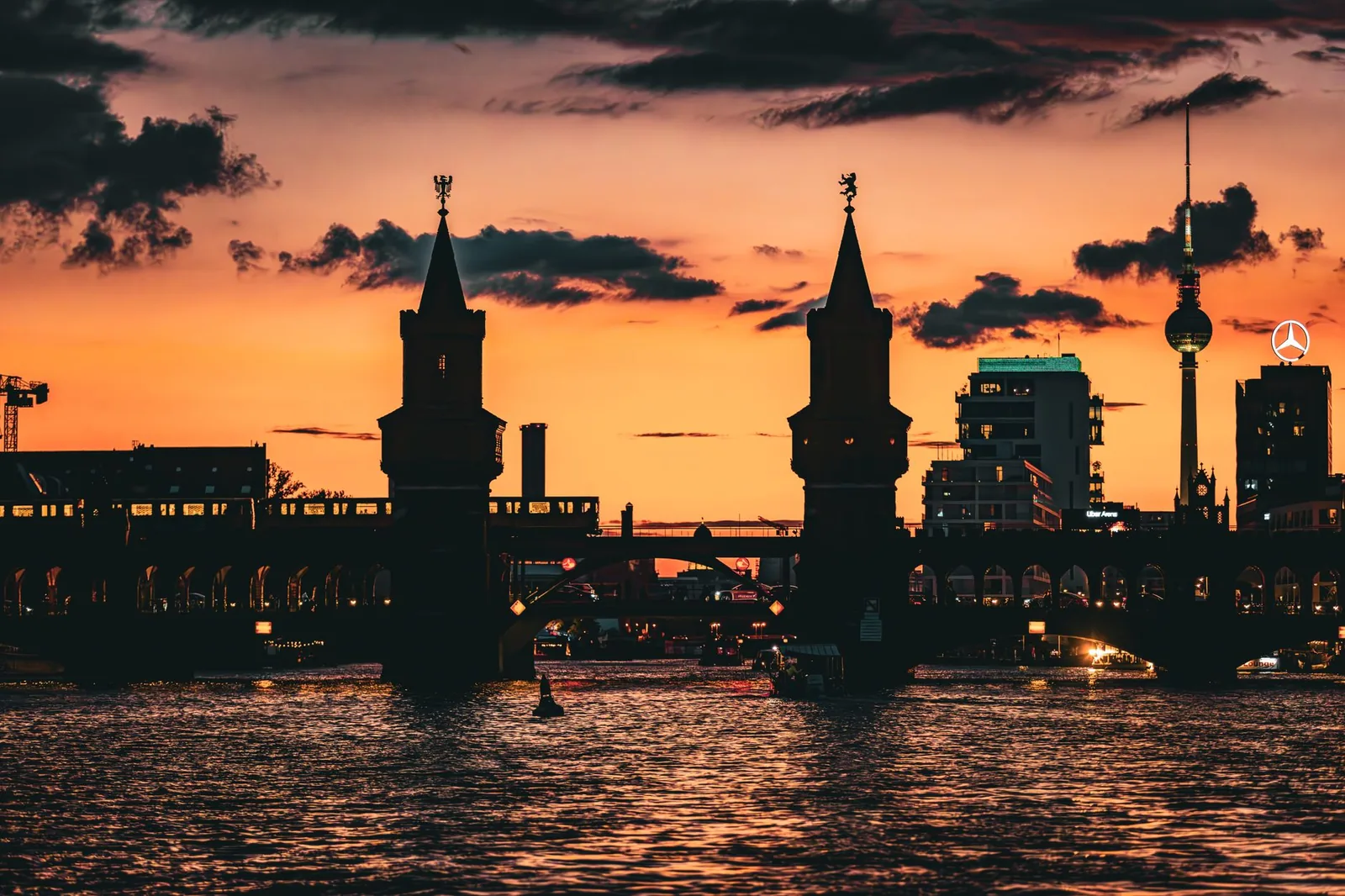 Coucher de soleil flamboyant sur le pont Oberbaum et la tour de télévision de Berlin, silhouettes reflétées sur la Spree