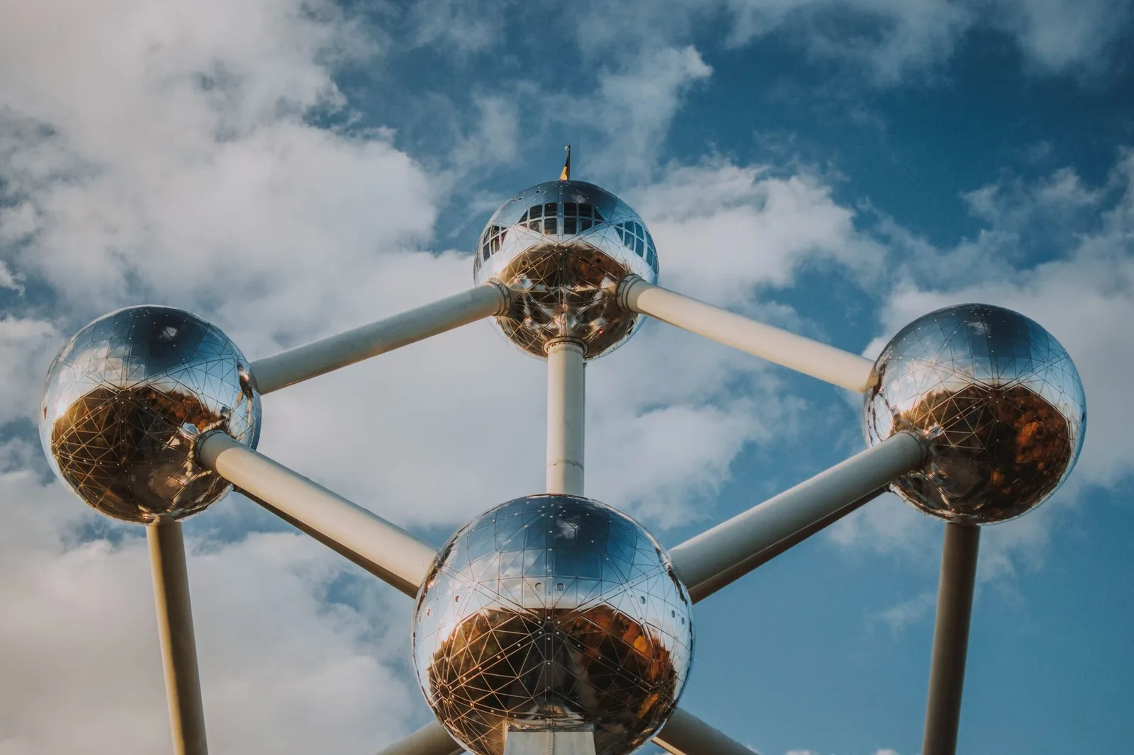 The Atomium in Brussels, its nine steel spheres gleaming against a blue sky dotted with clouds