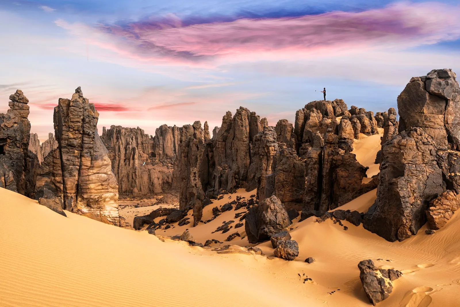 Formaciones rocosas del Tassili al amanecer sobre las dunas del Sahara argelino