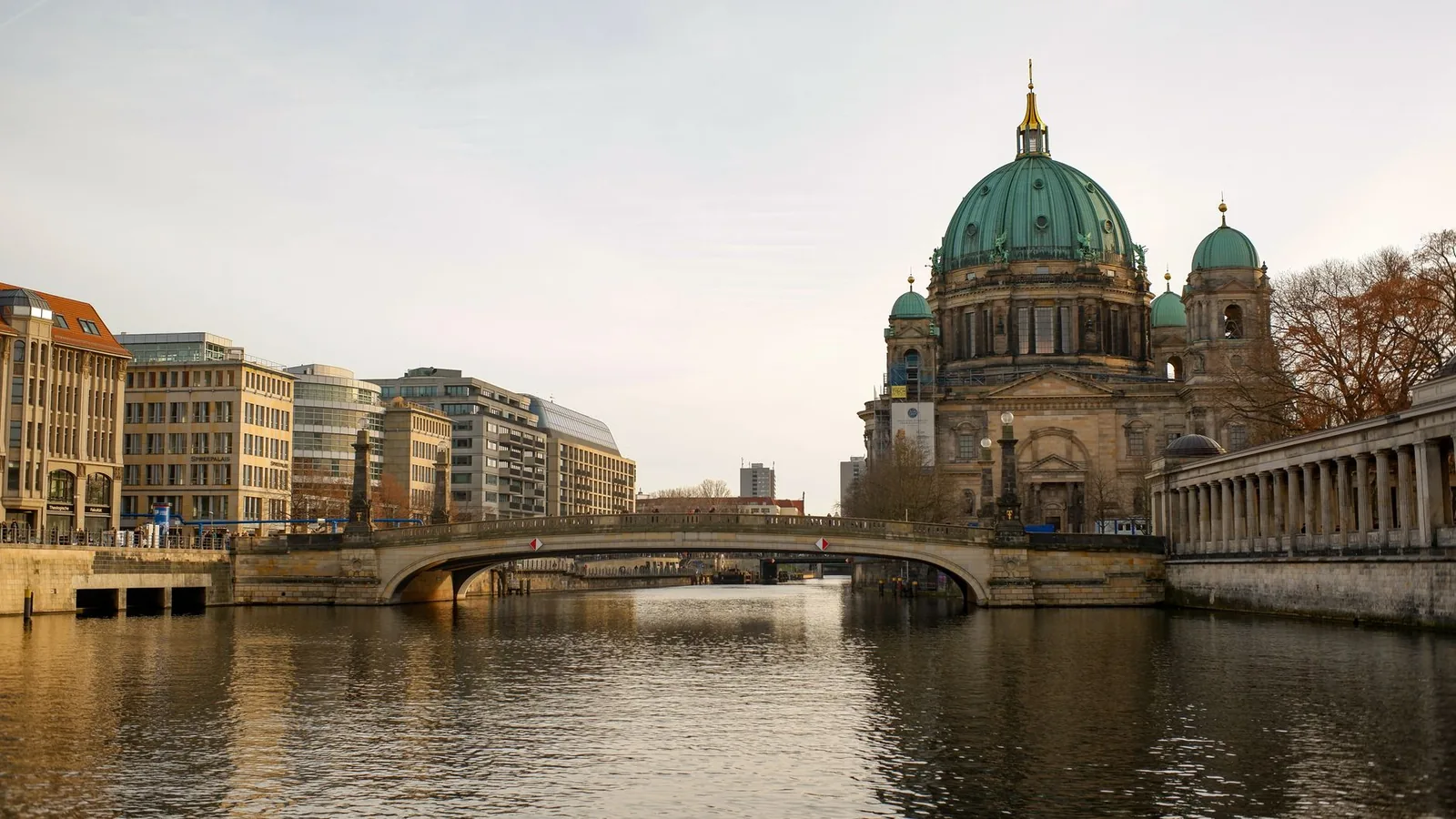 La cathédrale de Berlin et son dôme vert au bord de la Spree, avec un pont enjambant la rivière en pleine journée