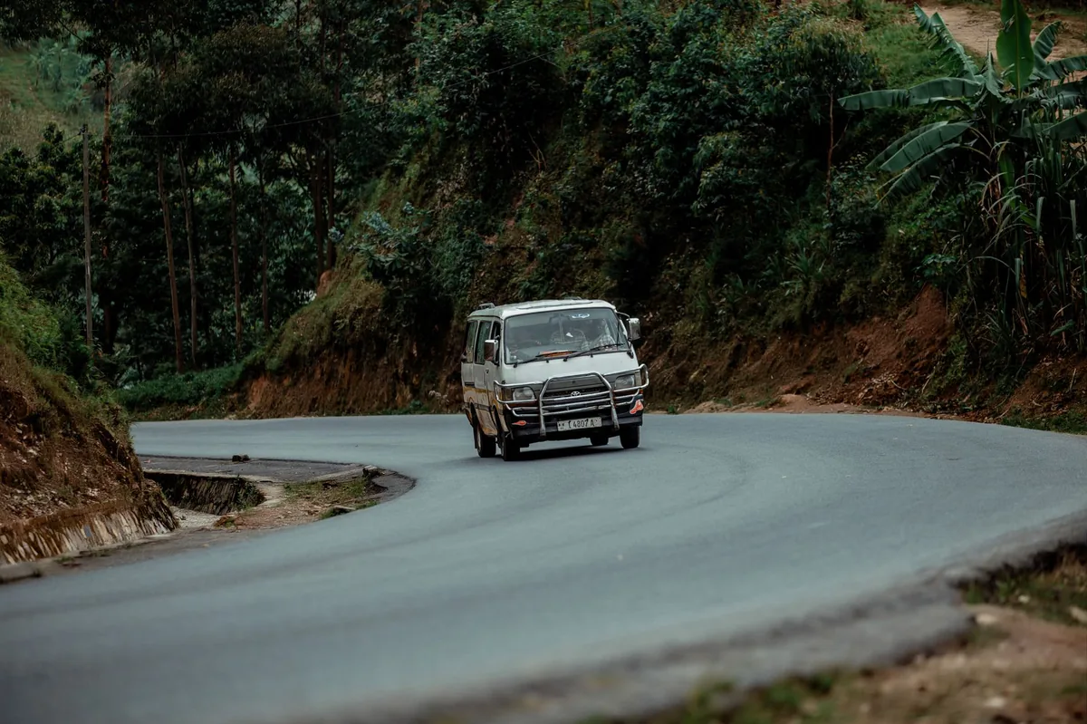 White furgon minibus on a rebuilt mountain highway winding through the Llogara pass in southern Albania