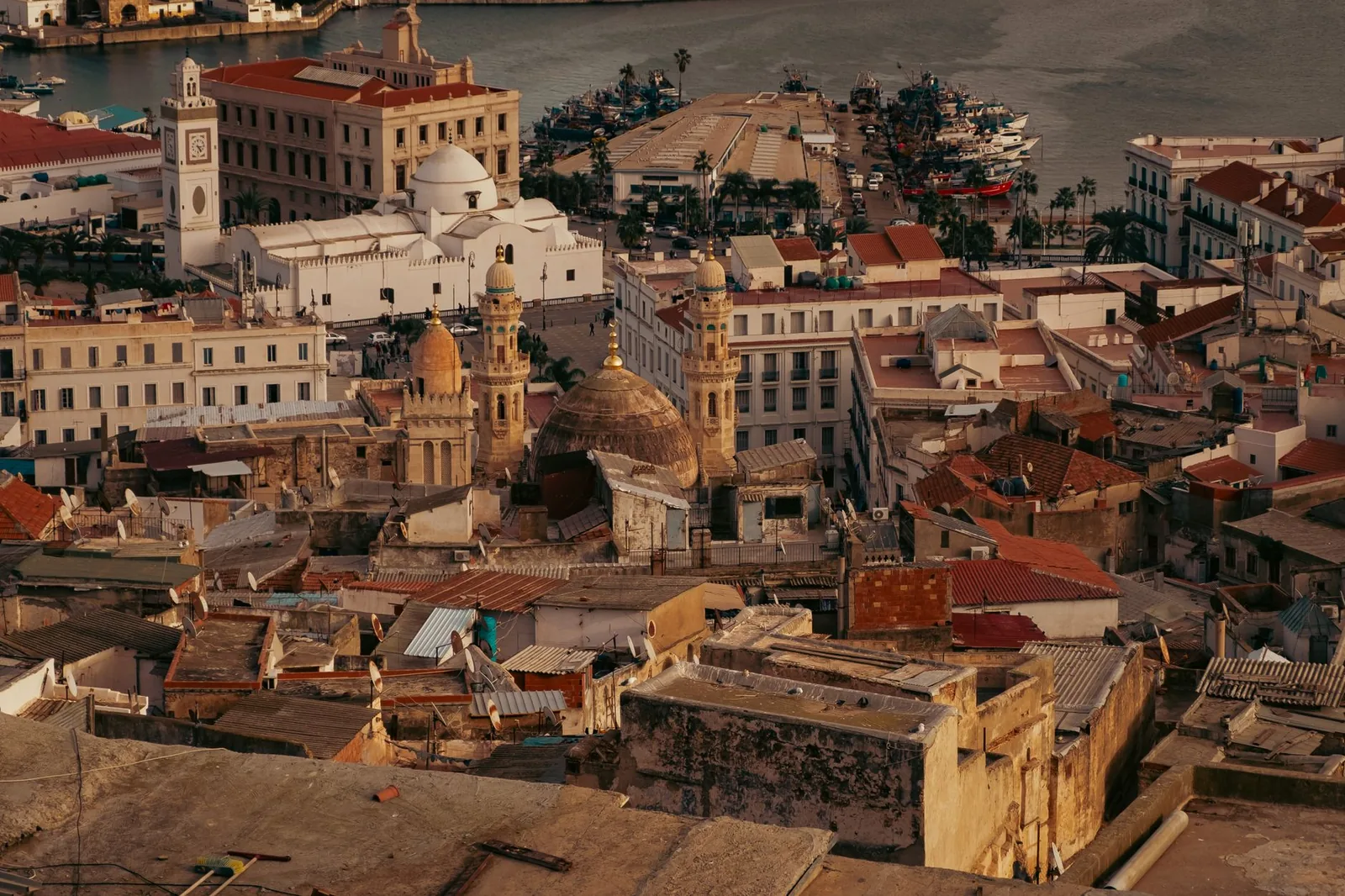 Tejados de la Casba de Argel y la bahia mediterranea con la luz dorada del atardecer