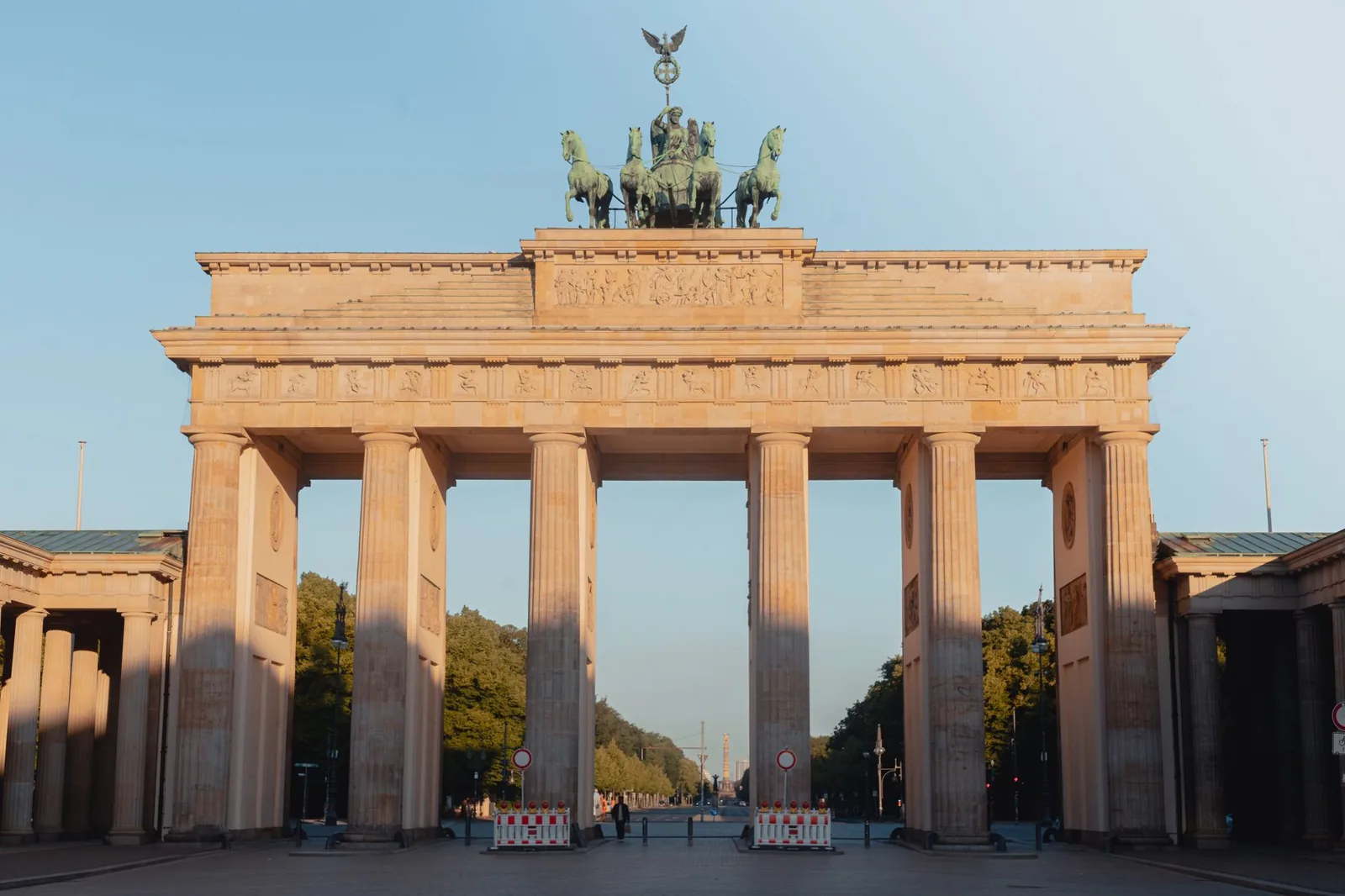 La porte de Brandebourg à Berlin baignée par la lumière dorée du soir, avec ses colonnes et son quadrige de bronze