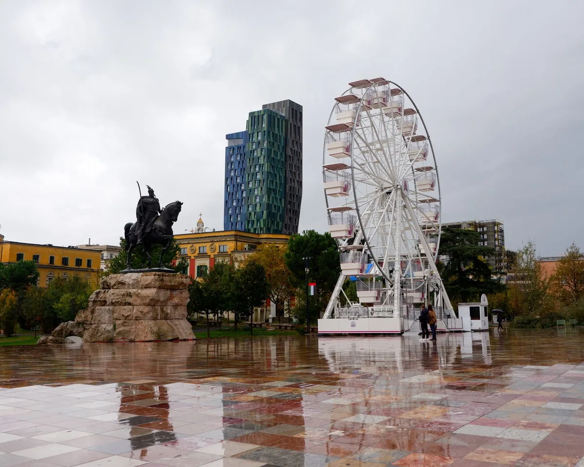 Place Skanderbeg à Tirana, Albanie, vaste esplanade avec la statue équestre de Skanderbeg et la mosquée Et'hem Bey au coucher du soleil
