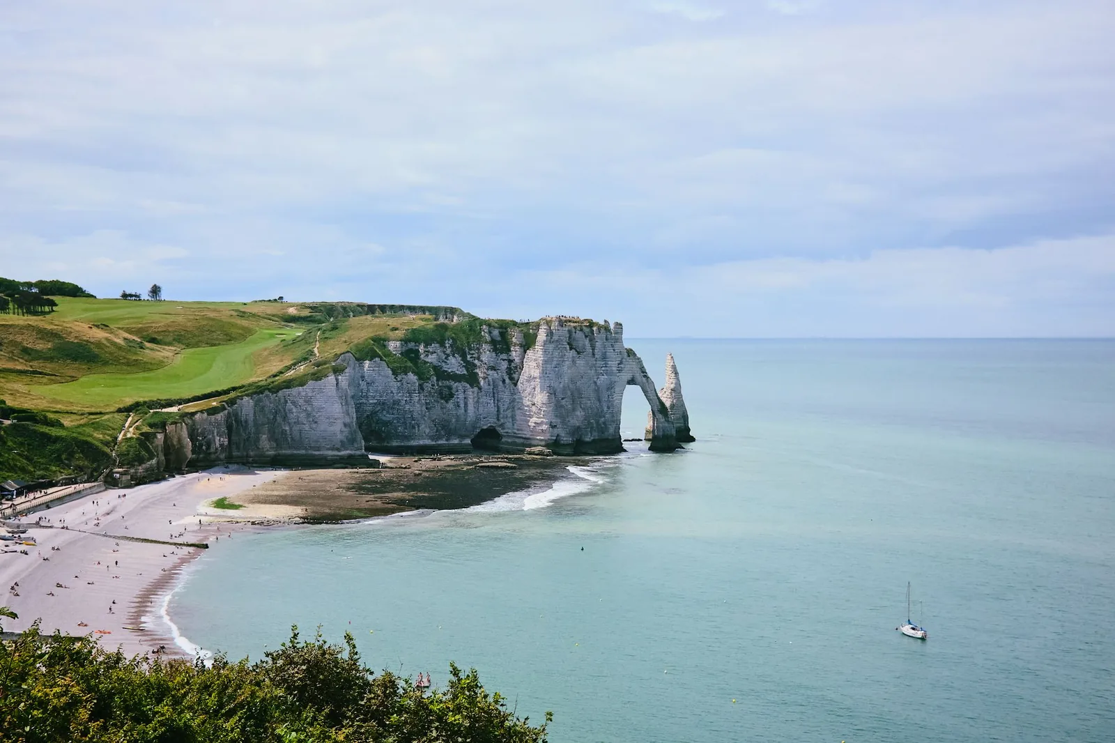 The white cliffs and natural arch of Etretat plunging into a turquoise sea, in Normandy