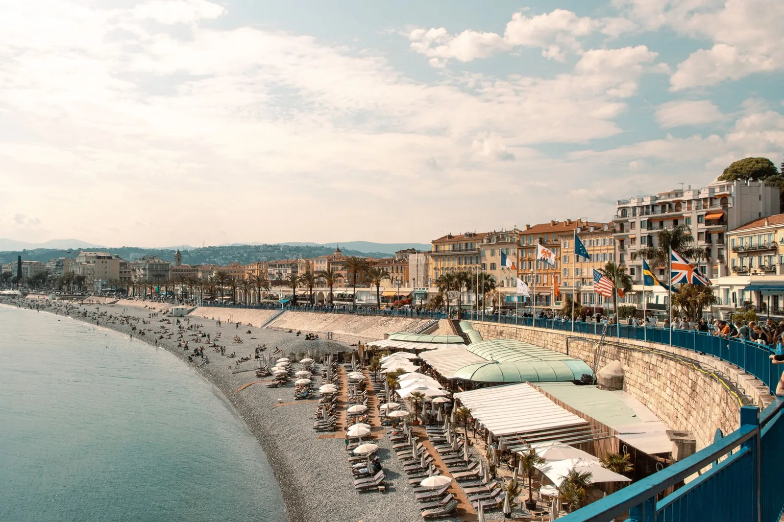 La Promenade des Anglais a Nice longe la plage de galets et la Baie des Anges, facades colorees et ciel degage