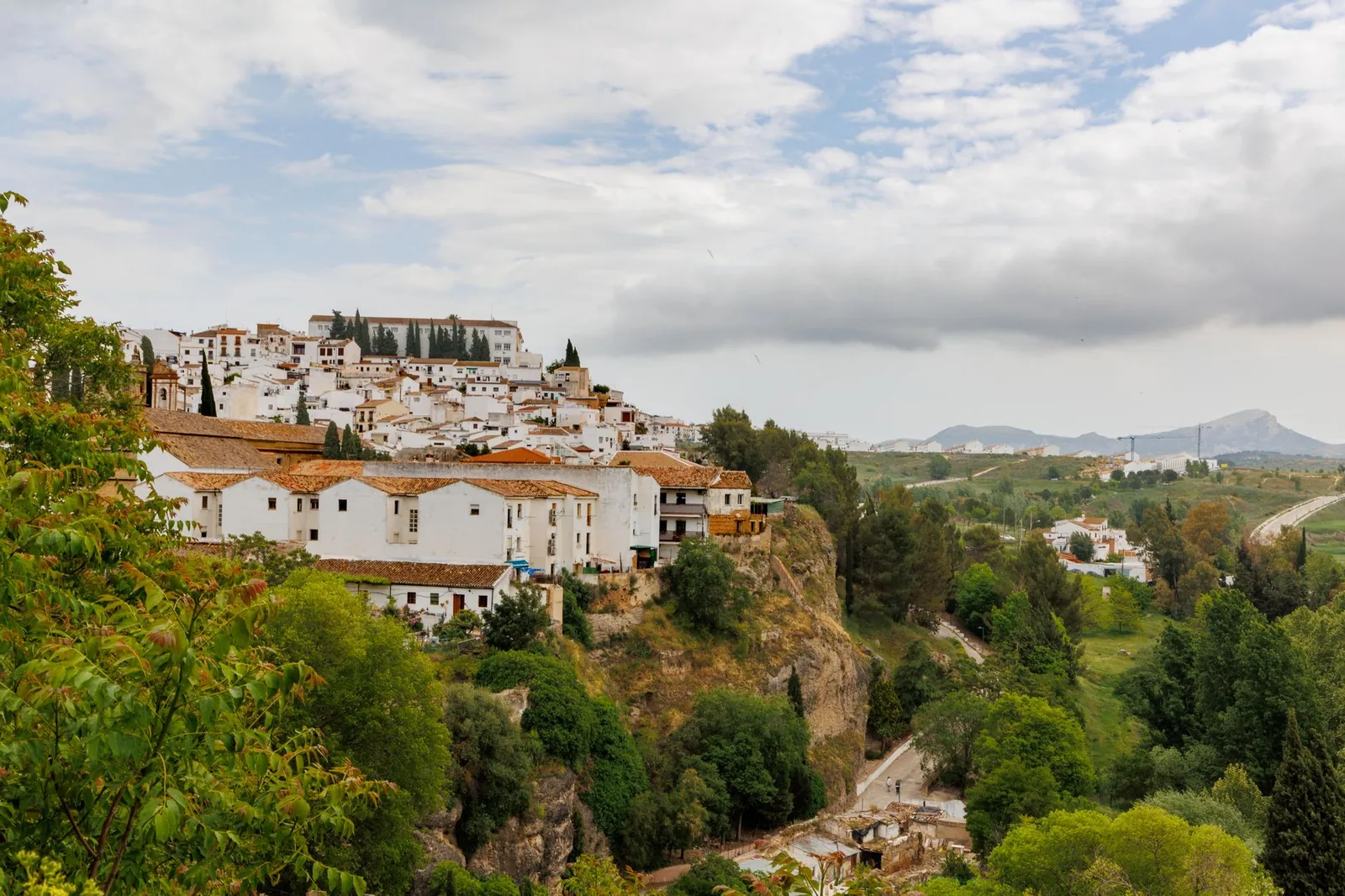 El pueblo blanco de Ronda asomado a su acantilado sobre una campiña verde en Andalucía